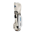 Front view of Malbon Golf Stand Bag in premium white PU leather, featuring blue cartoon golfer mascot on hood, 'MALBON' branding in blue, and black dual rain hoods.