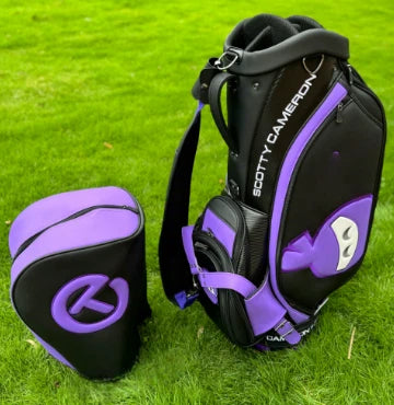 An alternate angle of the Scotty Cameron Camo Collage Tour Bag and headcover on the grass. This view showcases the bag's multiple pockets, adjustable straps, and the distinctive purple accents against the black PU material.
