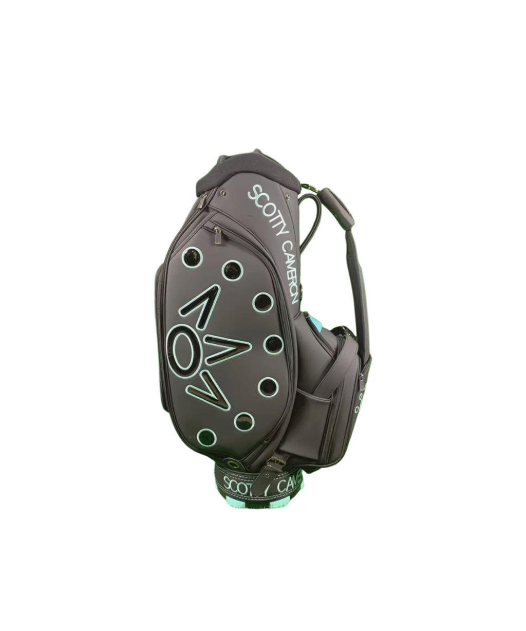 Angled rear view of the Scotty Cameron Supercar Staff Bag, highlighting the 'SCOTTY CAMERON' text on the hood, the side pocket construction, and the integrated dual-strap system.


