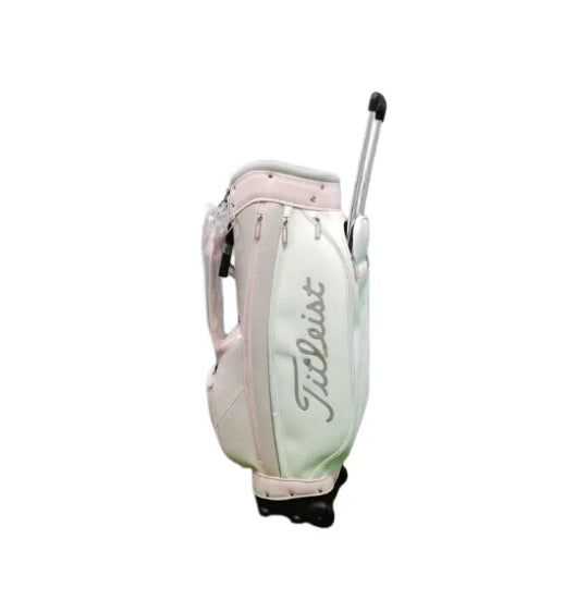 Angled view of the Titleist Waterproof Stand Golf Bag with handle extended, highlighting its durable PU construction, dual wheels, and stylish pastel color combination with the Titleist logo.